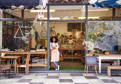 Street view of an independent café and bike shop with the owner at the door